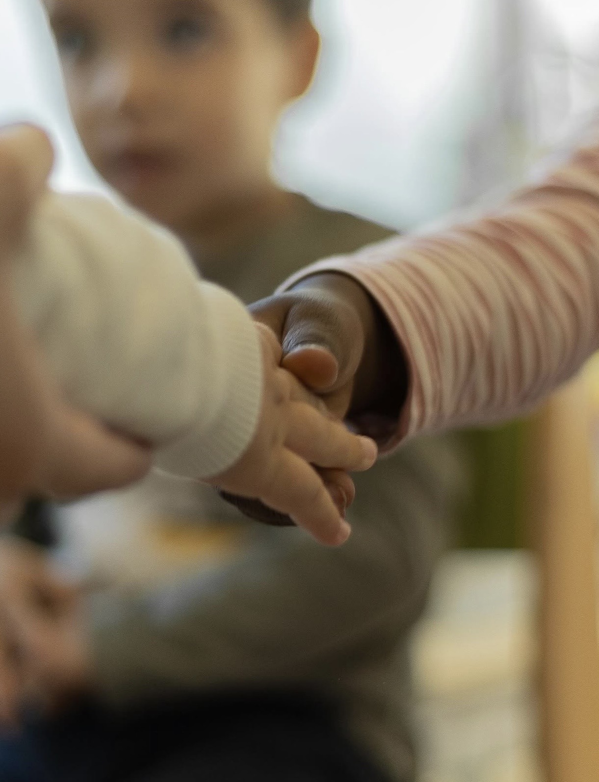 Mains d'enfants qui se tiennent, symbole de la diversité accueillie chez Kid's Land